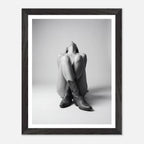 Framed black and white photo of a person wearing cowboy boots on a light gray background