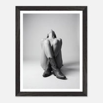 Framed black and white photo of a person wearing cowboy boots on a light gray background