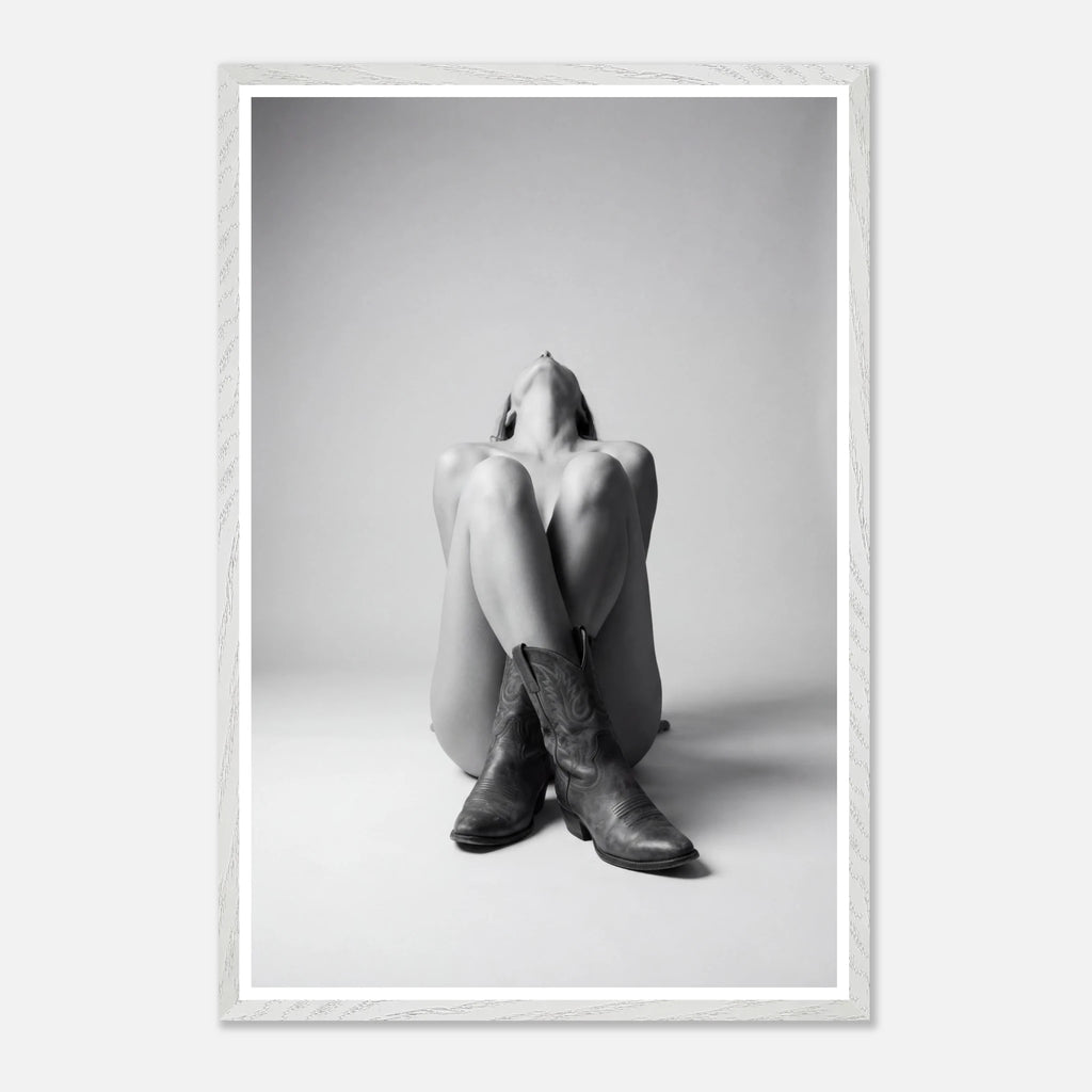 Framed black and white art print of a person sitting with legs crossed wearing cowboy boots.