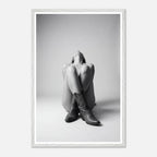 Framed black and white art print of a person sitting with legs crossed wearing cowboy boots.