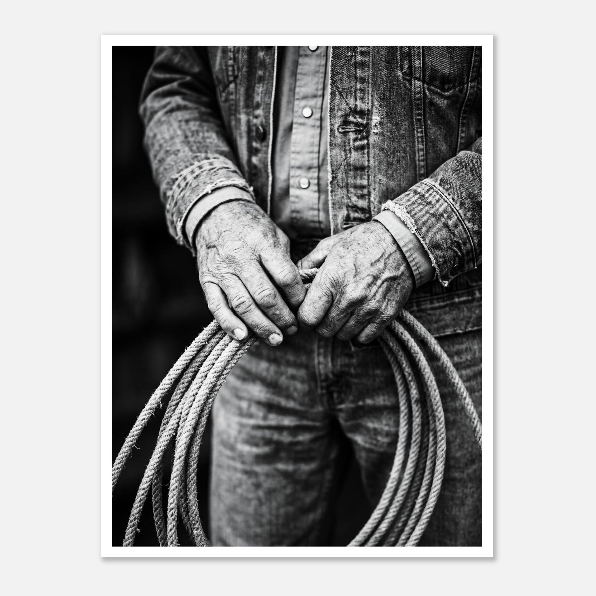 Black and white photograph of cowboy hands holding a coiled rope wearing denim, western ranch wall art.