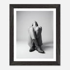 Framed black and white photo of a person wearing cowboy boots on a light background