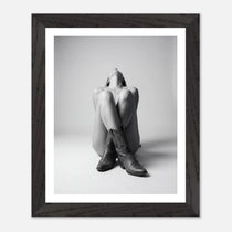 Framed black and white photo of a person wearing cowboy boots on a light background