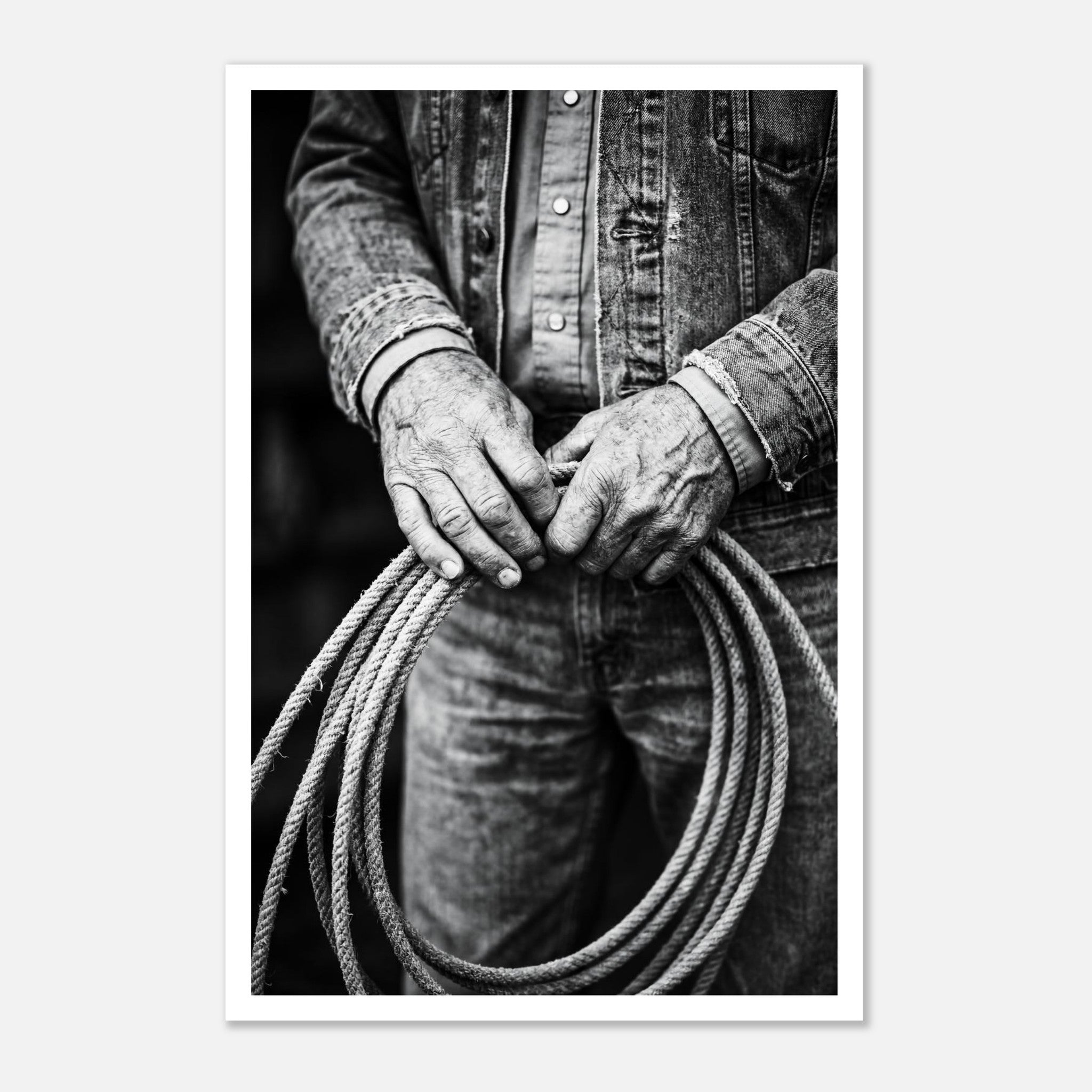 Black and white photograph of cowboy hands holding a coiled rope wearing denim, western ranch wall art.