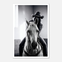 Black and white photograph of a cowgirl riding a horse head on wearing a cowboy hat, western equestrian wall art.