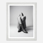 Framed black and white photo of a person wearing cowboy boots sitting on the floor.