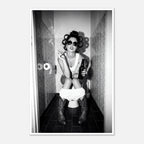 Black and white photograph of a rebellious cowgirl wearing cowboy boots and sunglasses sitting in a tiled restroom holding a cigarette and beer.