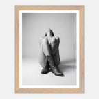 Framed black and white photo of a person wearing cowboy boots on a light gray background