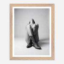 Framed black and white photo of a person wearing cowboy boots on a light gray background