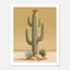 Minimalist desert poster featuring a tall saguaro cactus with a burnt orange bloom, surrounded by desert plants and rocks against a soft golden sky in muted mid century tones.