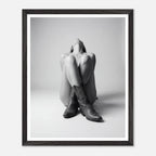 Framed black and white art print of a person sitting with legs crossed wearing cowboy boots.