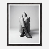 Framed black and white art print of a person sitting with legs crossed wearing cowboy boots.