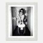 Black and white photograph of a rebellious cowgirl wearing cowboy boots and sunglasses sitting in a tiled restroom holding a cigarette and beer.