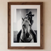 Black and white photograph of a cowgirl riding a horse head on wearing a cowboy hat, western equestrian wall art.