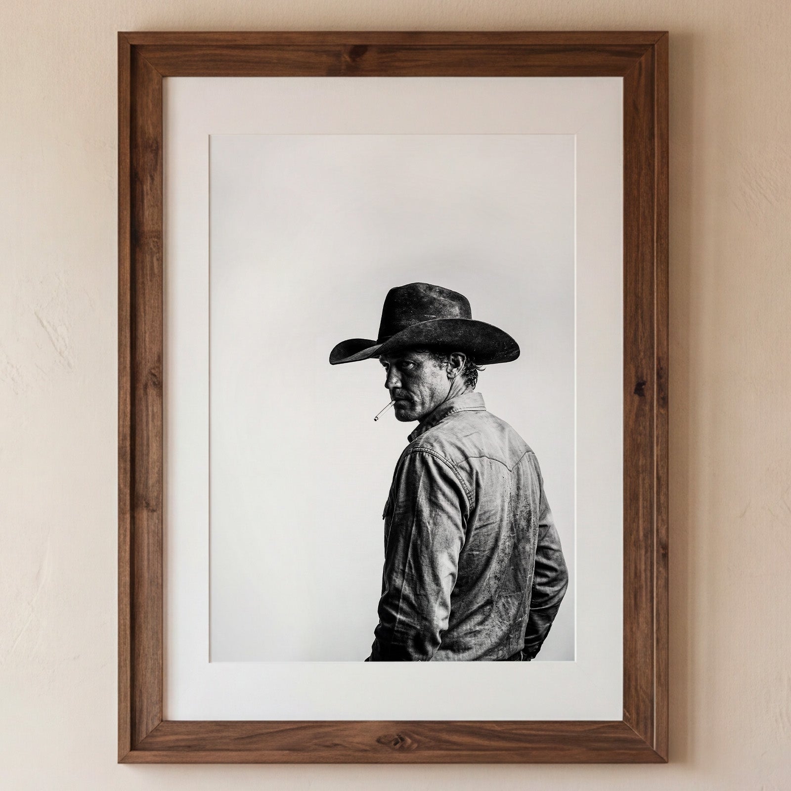 Black and white photograph of a rodeo cowboy wearing a western hat and cigarette, turning toward the camera after competition, western cowboy wall art poster.