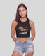 A woman modeling a black sleeveless crop top with a red 'MONTAVOR' text graphic and a western horse illustration, paired with light-wash distressed denim shorts, against a solid light gray background.