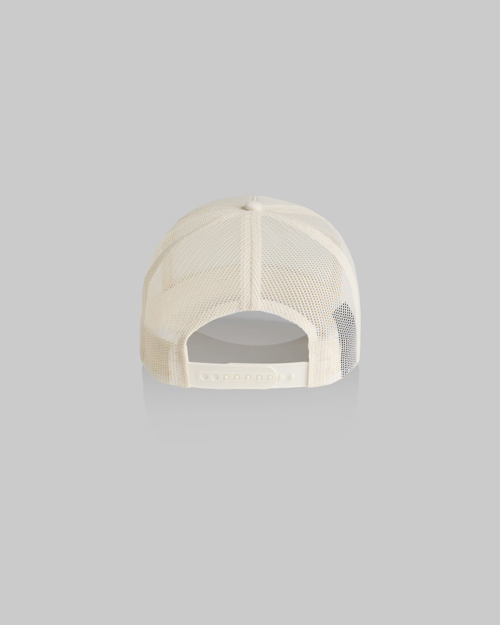 Back view of a cream-colored trucker cap with mesh back panels and an adjustable snap closure, shown on a solid gray background.