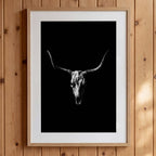 Black and white photograph of a longhorn skull with wide sweeping horns centered against a dark background, western wall art poster.