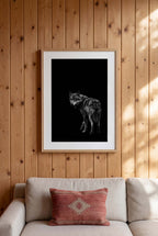 Black and white portrait of a lone wolf standing in shadow looking toward the viewer, wildlife wall art poster.