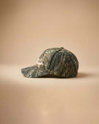 Camouflage baseball cap with 'Midnight Rodeo Club' text on a beige background