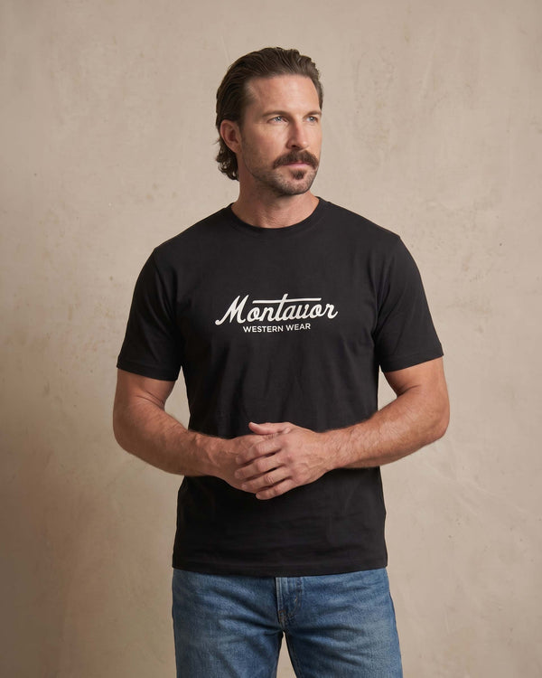 Man wearing a black t-shirt with 'Montavor Western Wear' logo against a beige background