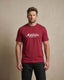 Man wearing a red t-shirt with 'Montavor Western Wear' logo against a beige background