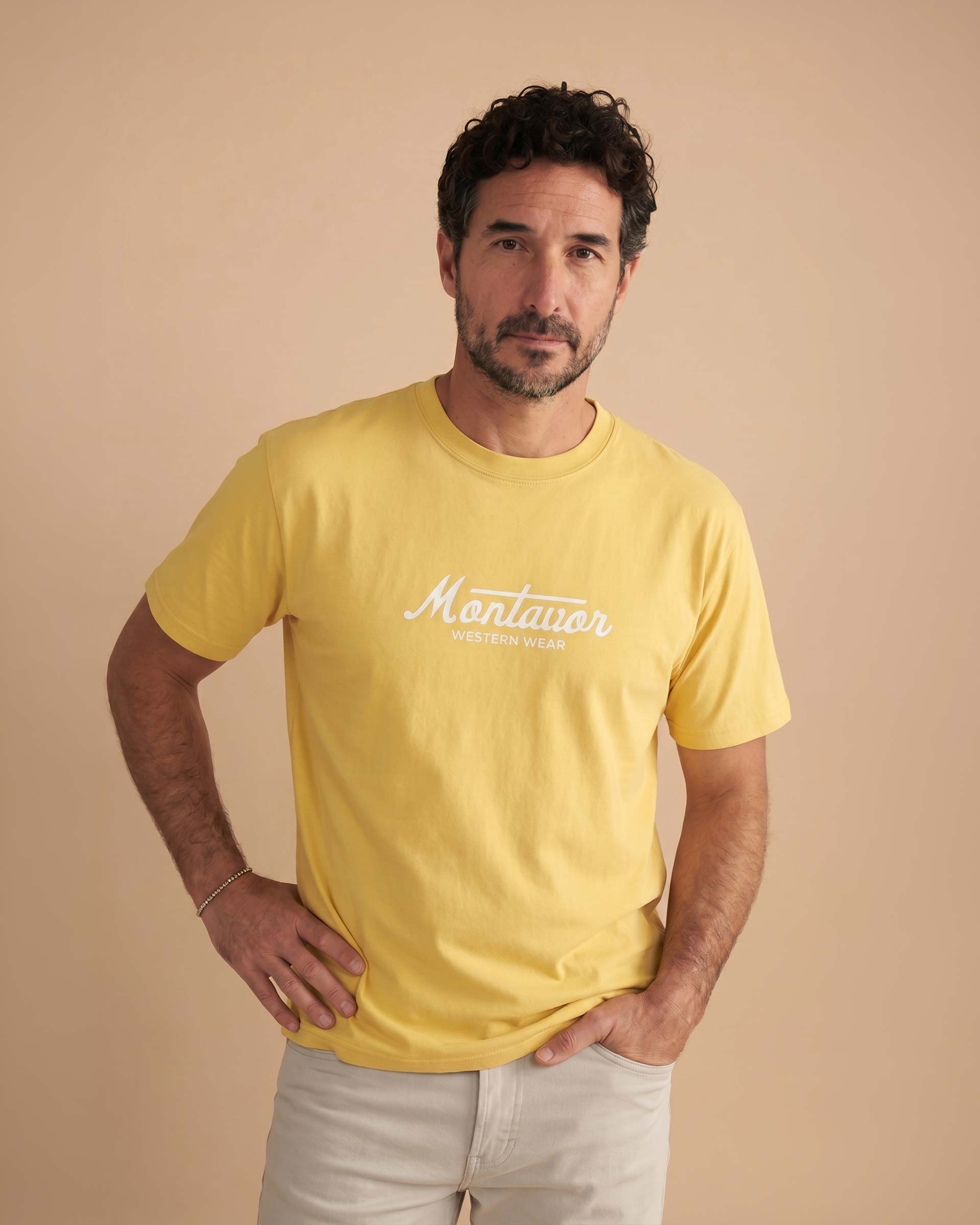 Man wearing a yellow t-shirt with 'Montavor' branding against a beige background
