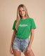 Woman wearing a green t-shirt with 'Montavor Western Wear' text on a beige background