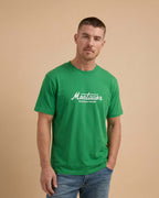 Man wearing a green t-shirt with 'Montavor' logo on a beige background