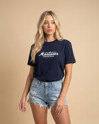 Woman wearing a navy blue t-shirt with 'Montavor' logo on a beige background