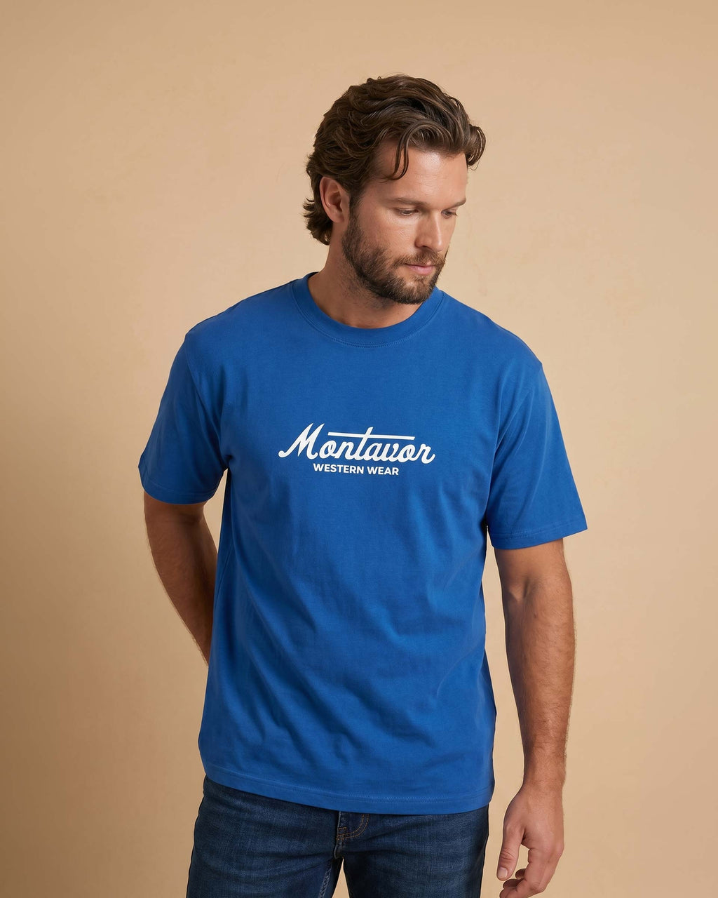 Man wearing a blue t-shirt with 'Montavor Western Wear' logo on a beige background