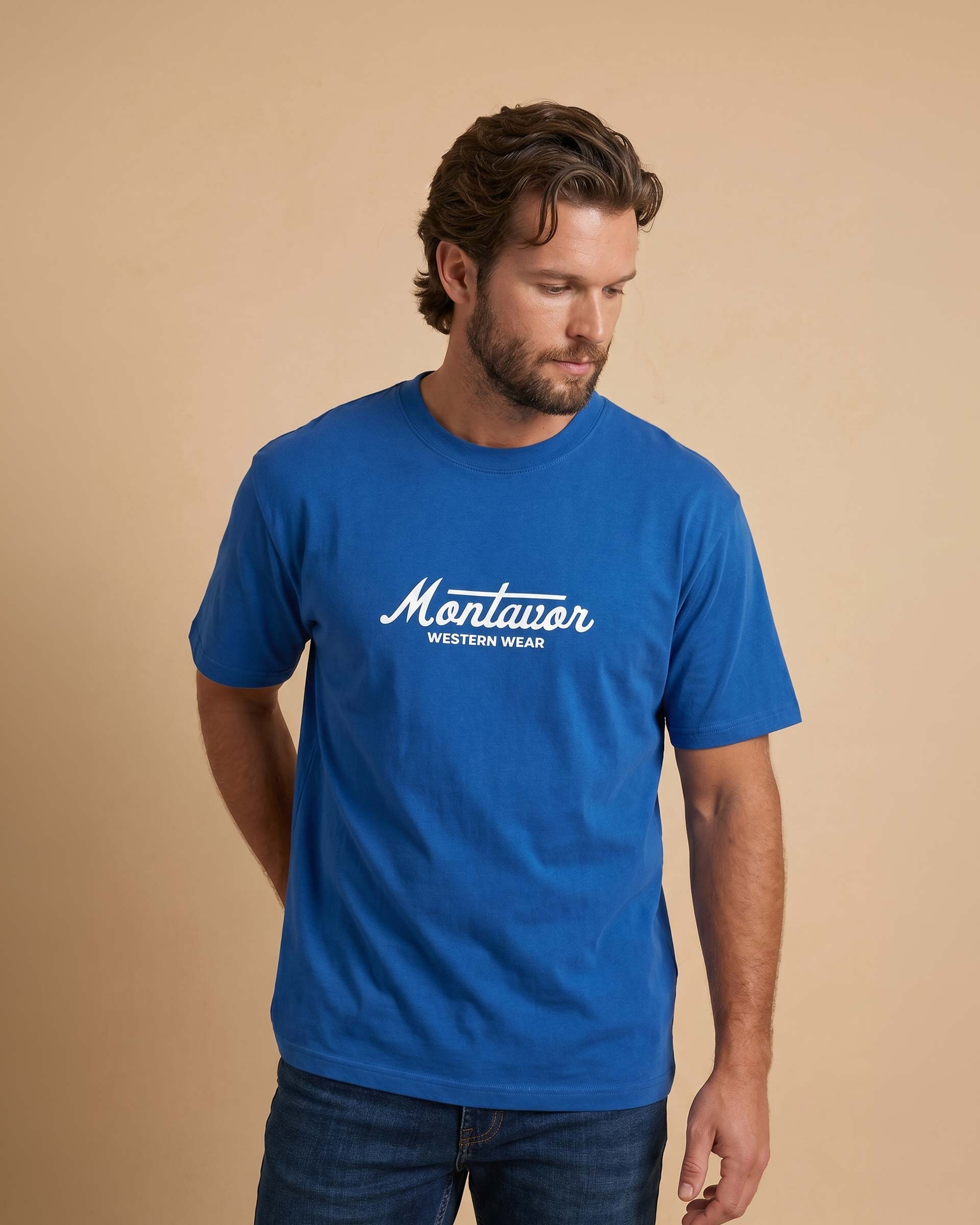 Man wearing a blue t-shirt with 'Montavor Western Wear' logo on a beige background