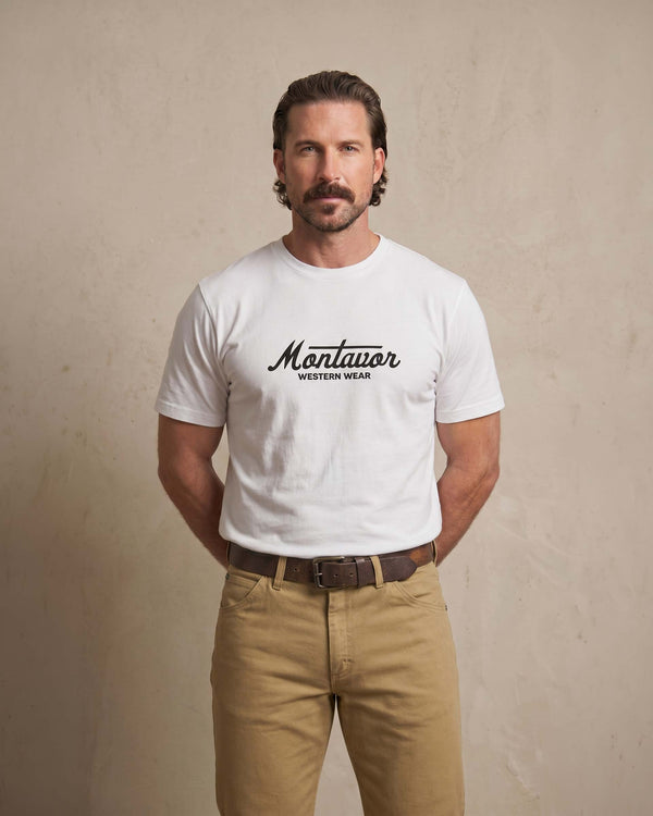 Man wearing a white t-shirt with 'Mon Western Wear' text against a beige backgroundavor