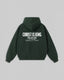 A dark forest green hoodie shown from the back, featuring white printed text that reads 'CHRIST IS KING' with smaller text below reading 'ONE NATION UNDER GOD' and 'Standing for Freedom'. The hoodie is displayed flat against a neutral light gray background.