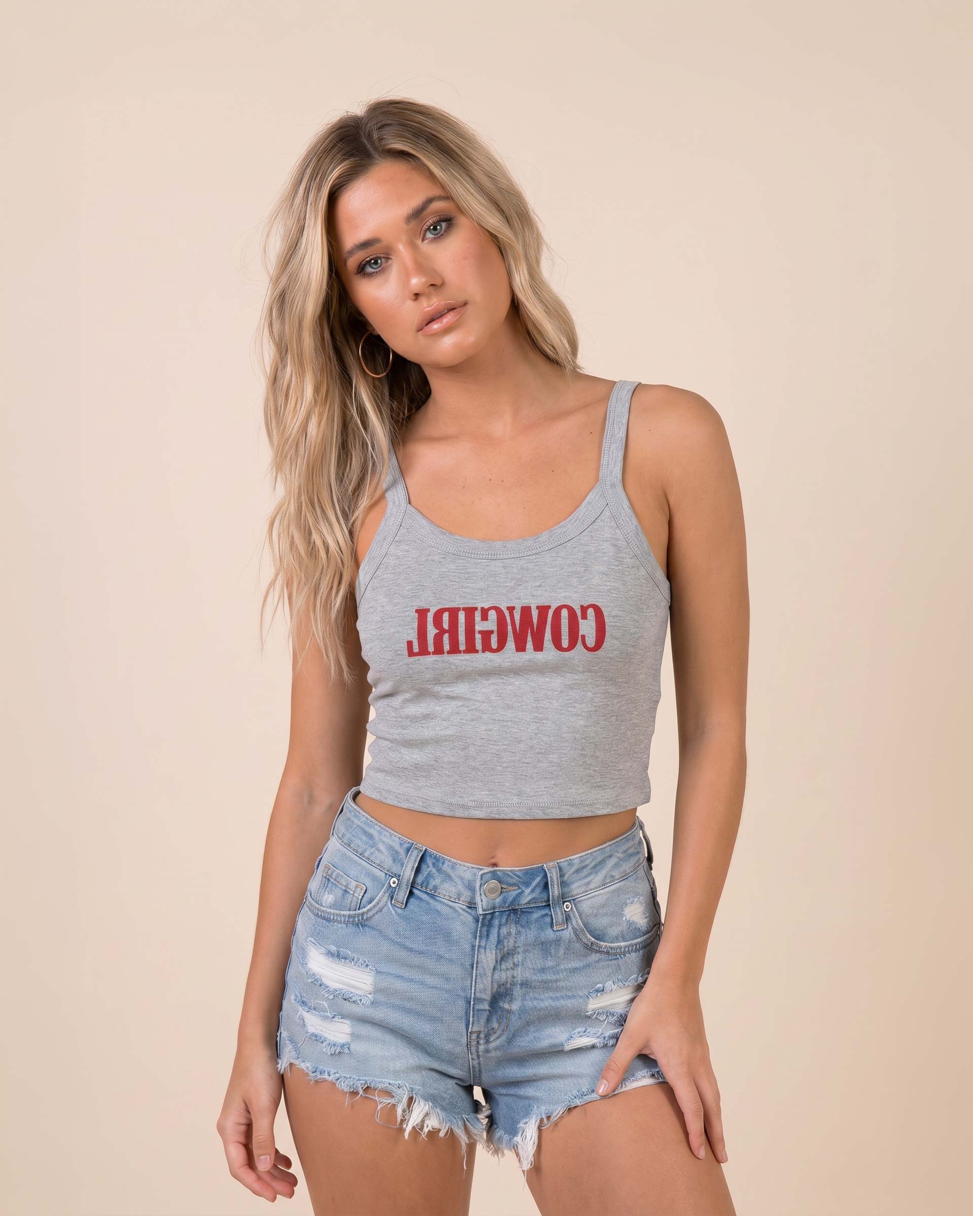 Fitted western-inspired strap tank top featuring mirrored “Cowgirl” typography on the front with a soft micro rib silhouette.