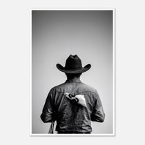 Black and white photograph of a rodeo cowboy viewed from behind wearing a western hat with a numbered rodeo tag pinned to his shirt after competition.