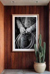 Black and white photograph of cowboy hands holding a coiled rope wearing denim, western ranch wall art.