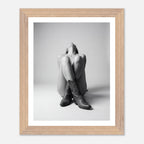 Framed black and white photo of a person wearing cowboy boots on a light gray background