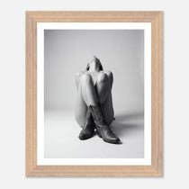 Framed black and white photo of a person wearing cowboy boots on a light gray background