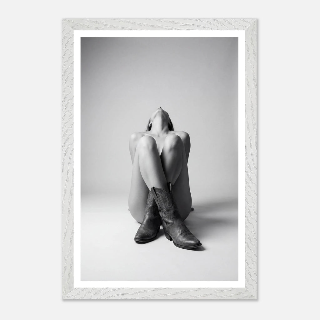 Person wearing a hoodie and boots sitting on the floor with a white frame.