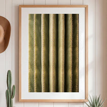 Framed artwork of a cactus on a wall with a hat and plants.