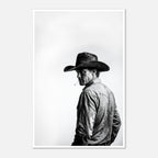 Black and white photograph of a rodeo cowboy wearing a western hat and cigarette, turning toward the camera after competition, western cowboy wall art poster.
