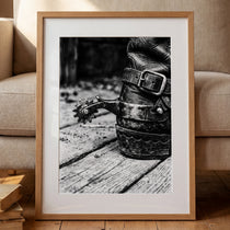 Black and white close up of a cowboy boot with metal spur on wooden floor, western ranch wall art.