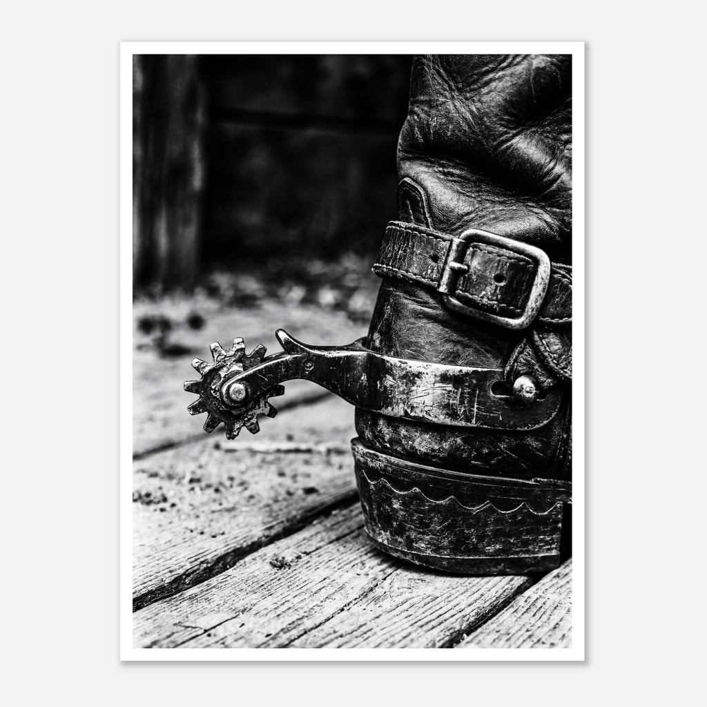Black and white close up of a cowboy boot with metal spur on wooden floor, western ranch wall art.
