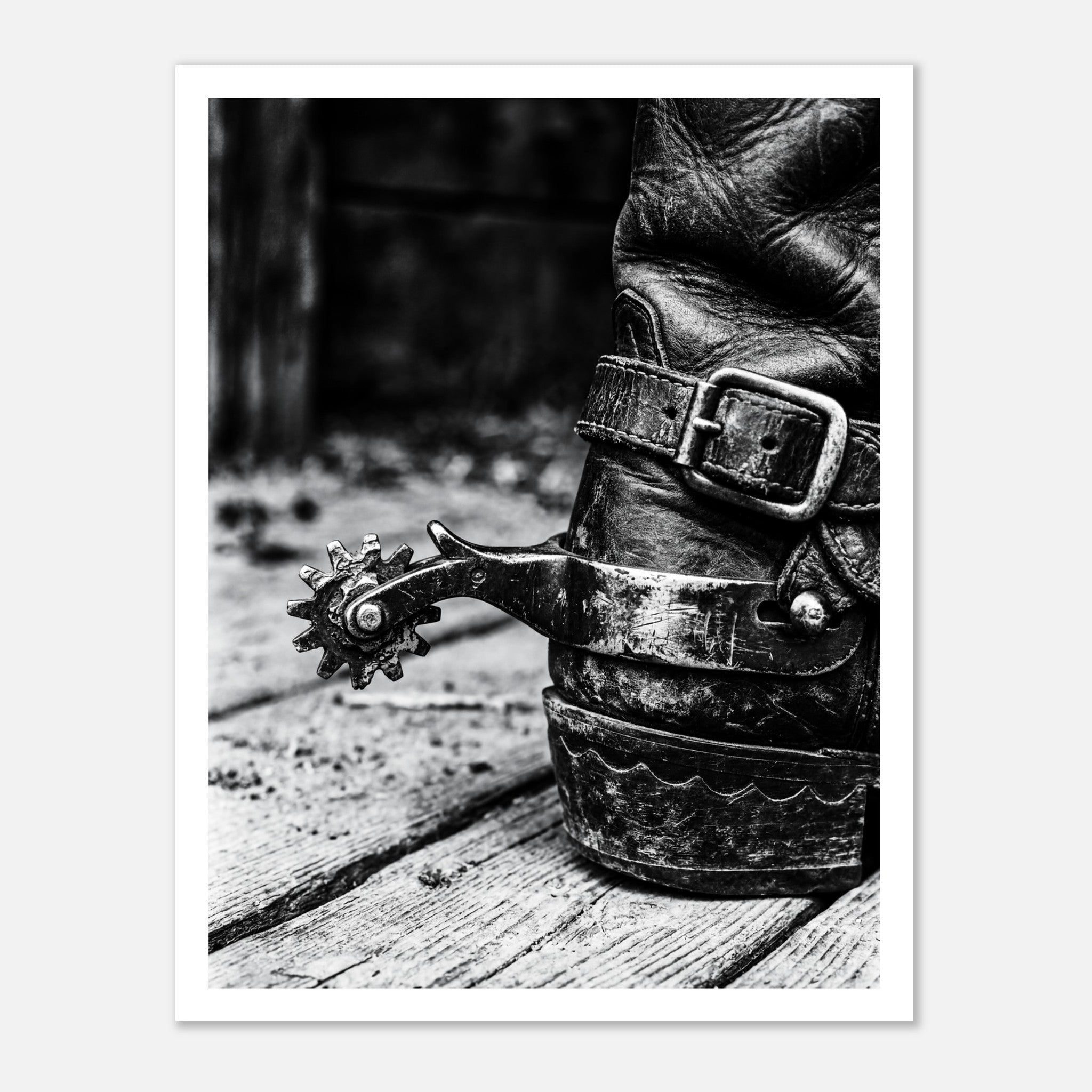Black and white close up of a cowboy boot with metal spur on wooden floor, western ranch wall art.