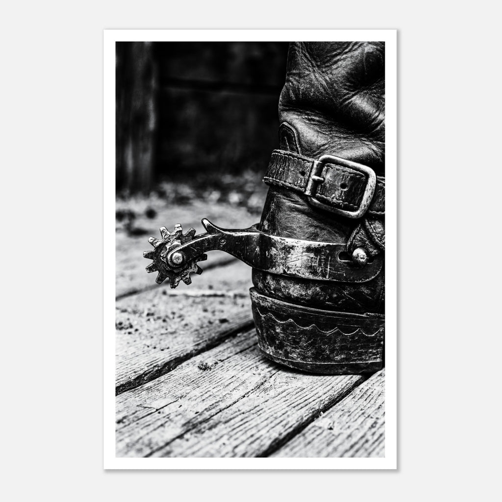 Black and white close up of a cowboy boot with metal spur on wooden floor, western ranch wall art.