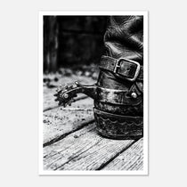 Black and white close up of a cowboy boot with metal spur on wooden floor, western ranch wall art.
