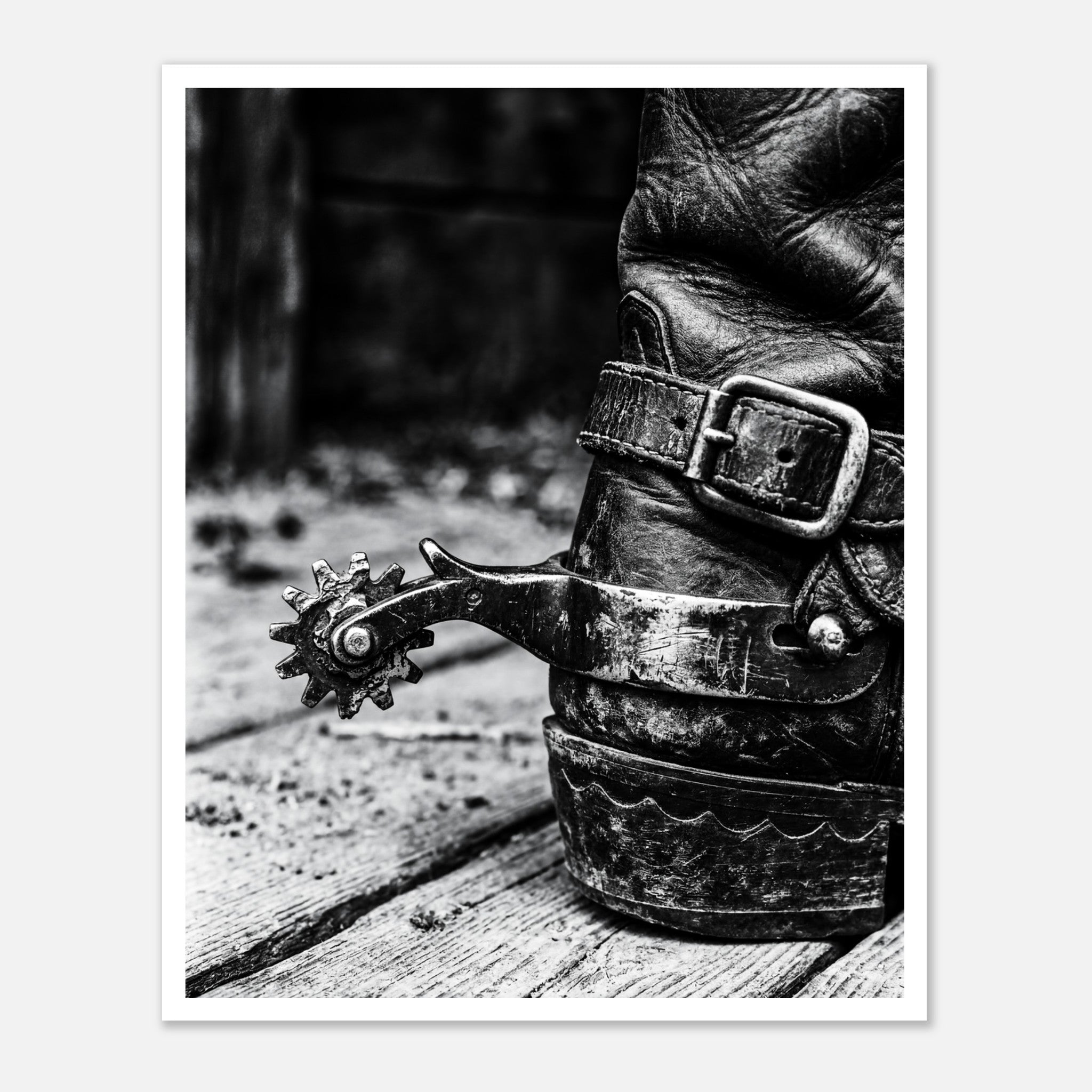 Black and white close up of a cowboy boot with metal spur on wooden floor, western ranch wall art.