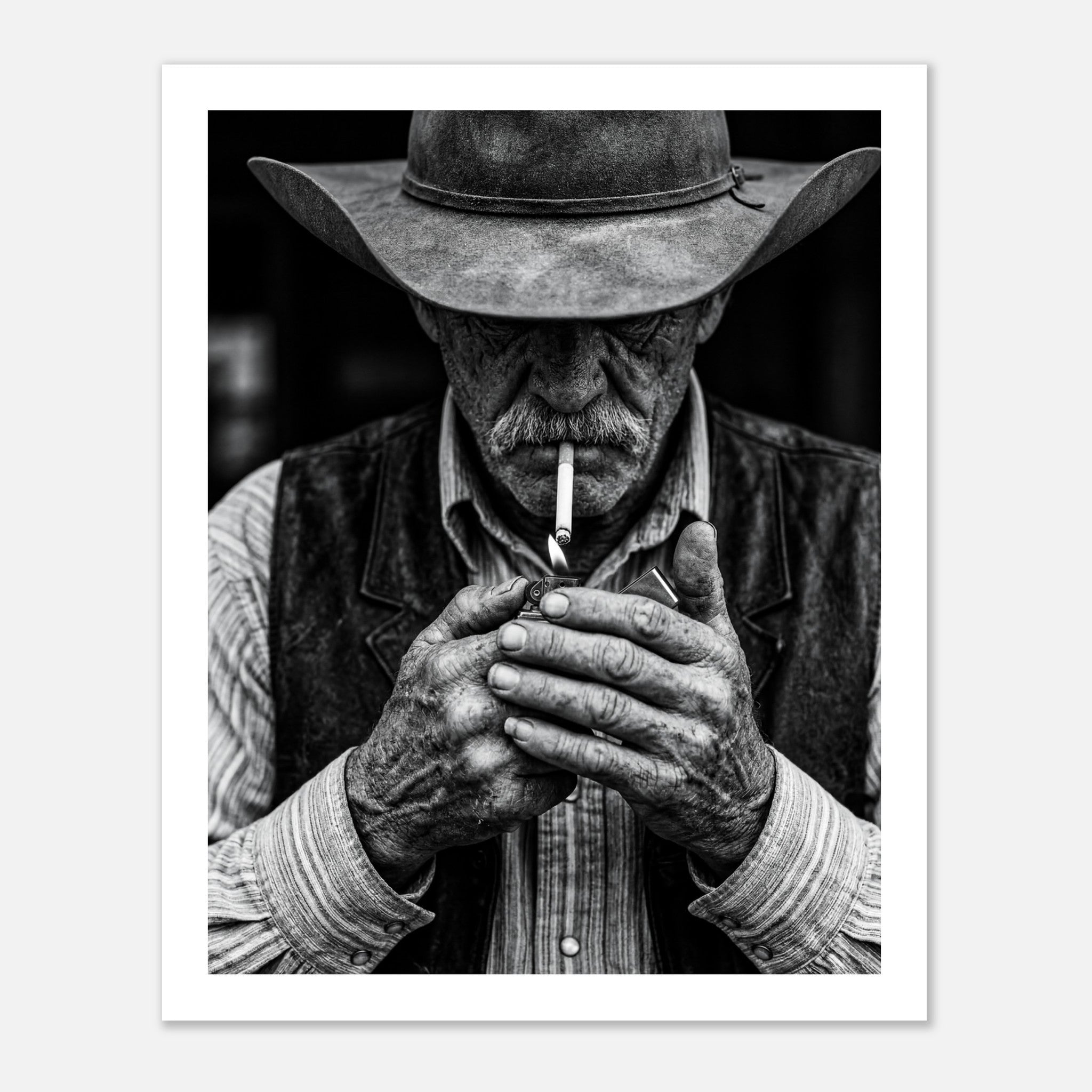 Black and white portrait of a cowboy lighting a cigarette wearing a hat, western wall art.