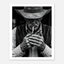 Black and white portrait of a cowboy lighting a cigarette wearing a hat, western wall art.